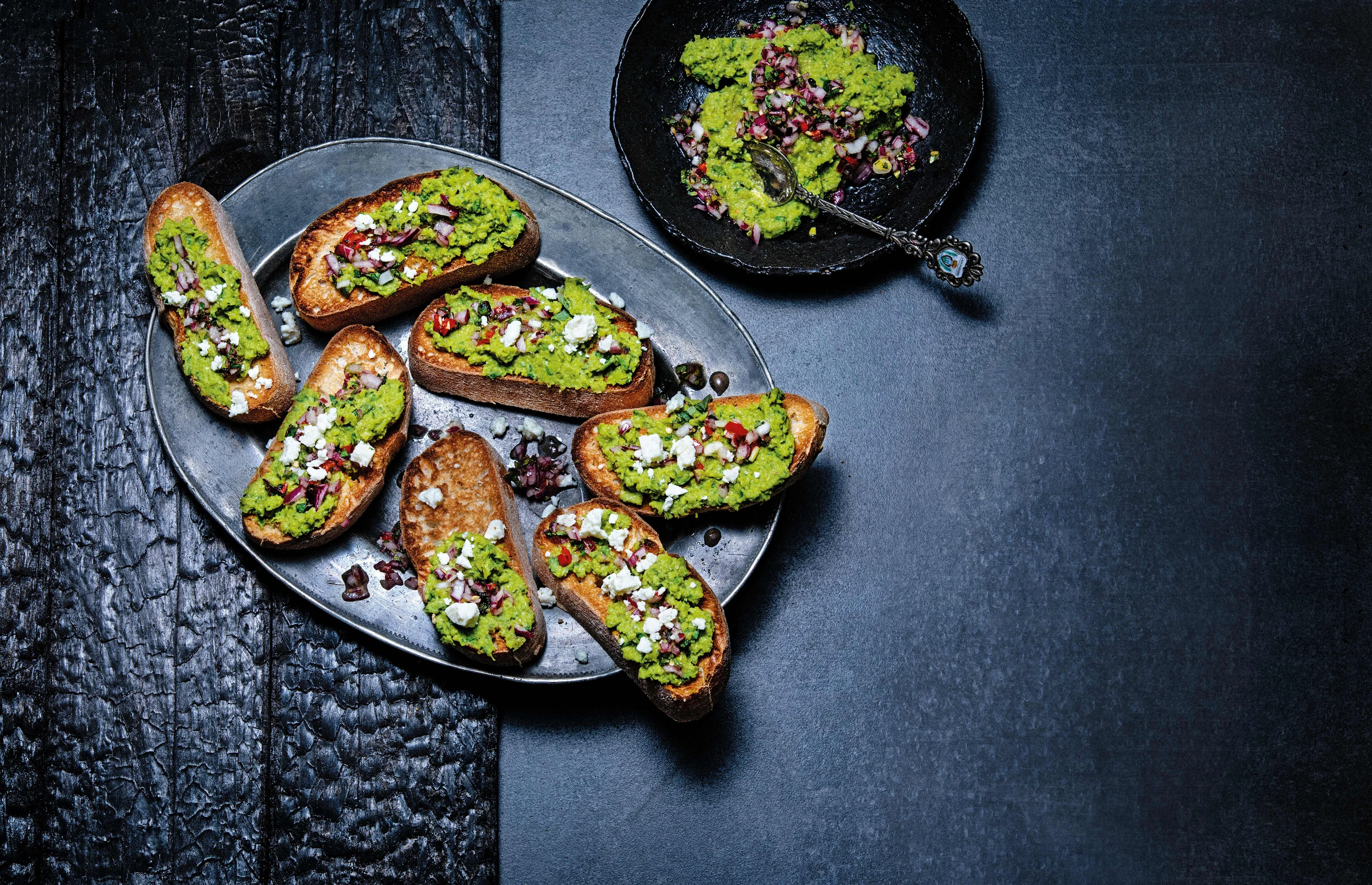 Crostini mit Erbsencreme, Feta und Chilisauce