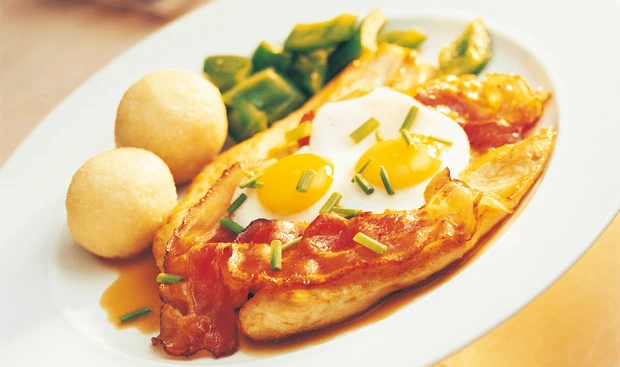 Hühnerschnitzel mit Speck und Spiegelei, dazu Erdäpfelknödel und Paprikagemüse