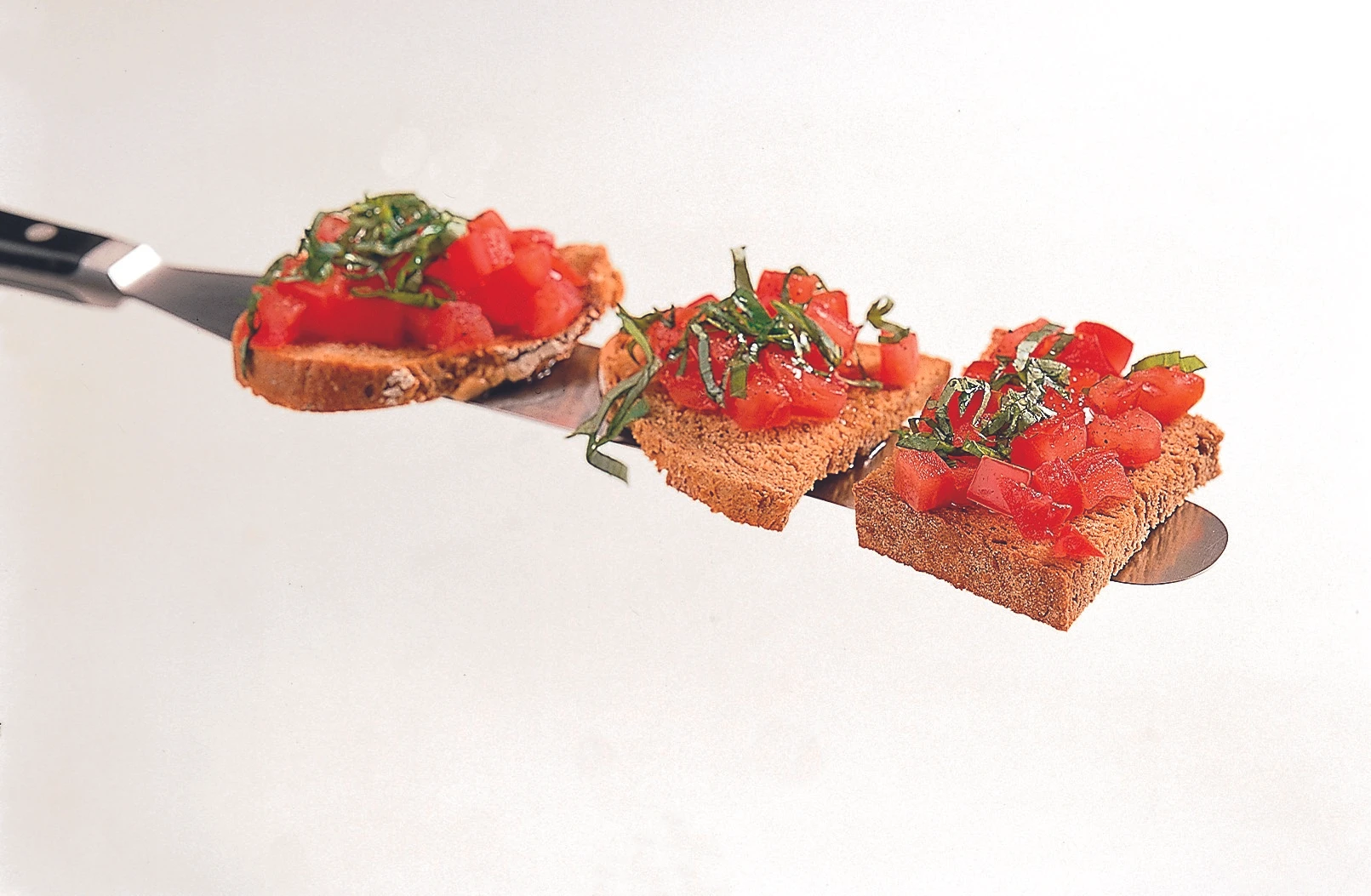 Getoastetes Schwarzbrot mit Tomaten und Basilikum