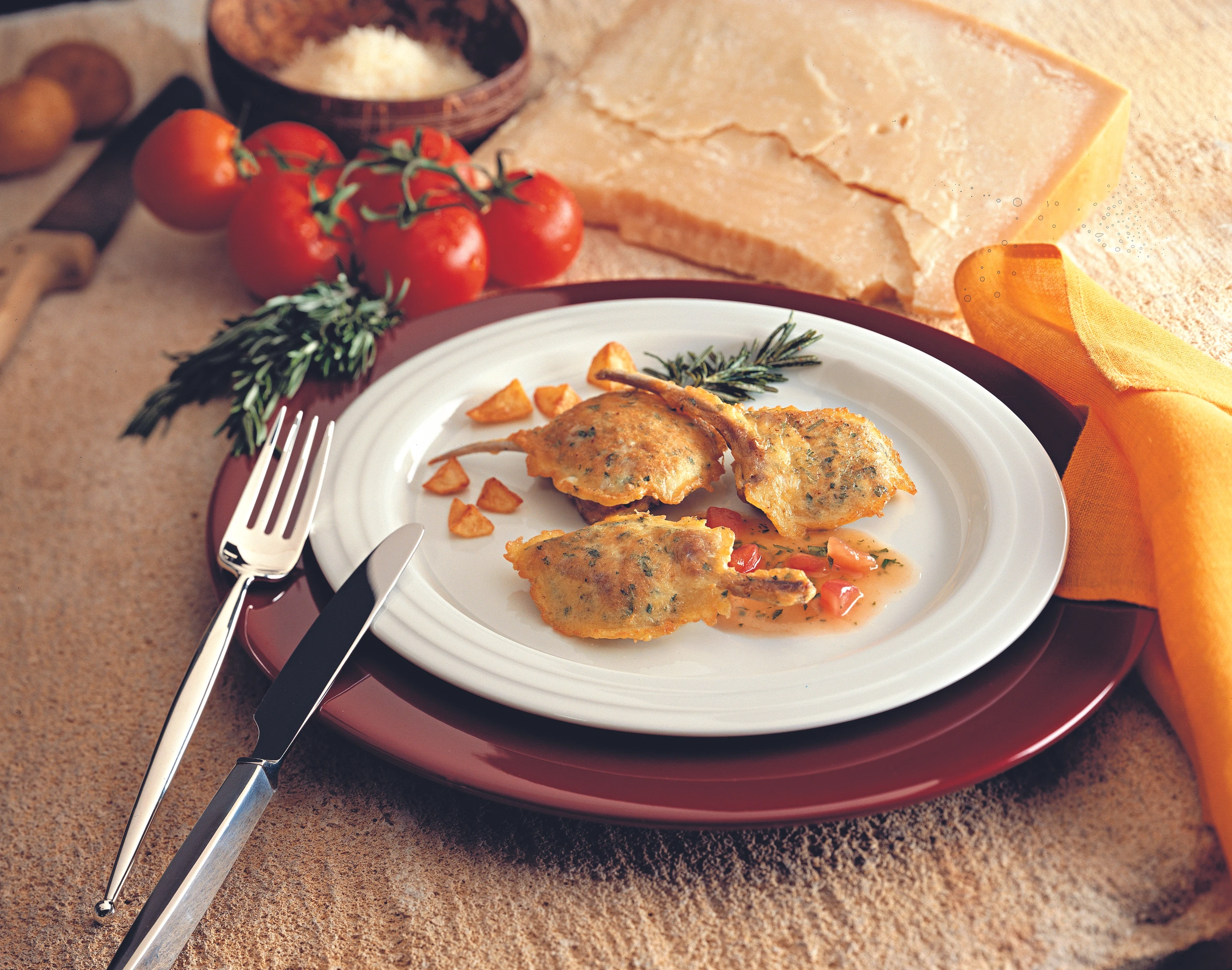 Lammkoteletts in Käsepanier mit warmer Paradeis-Vinaigrette