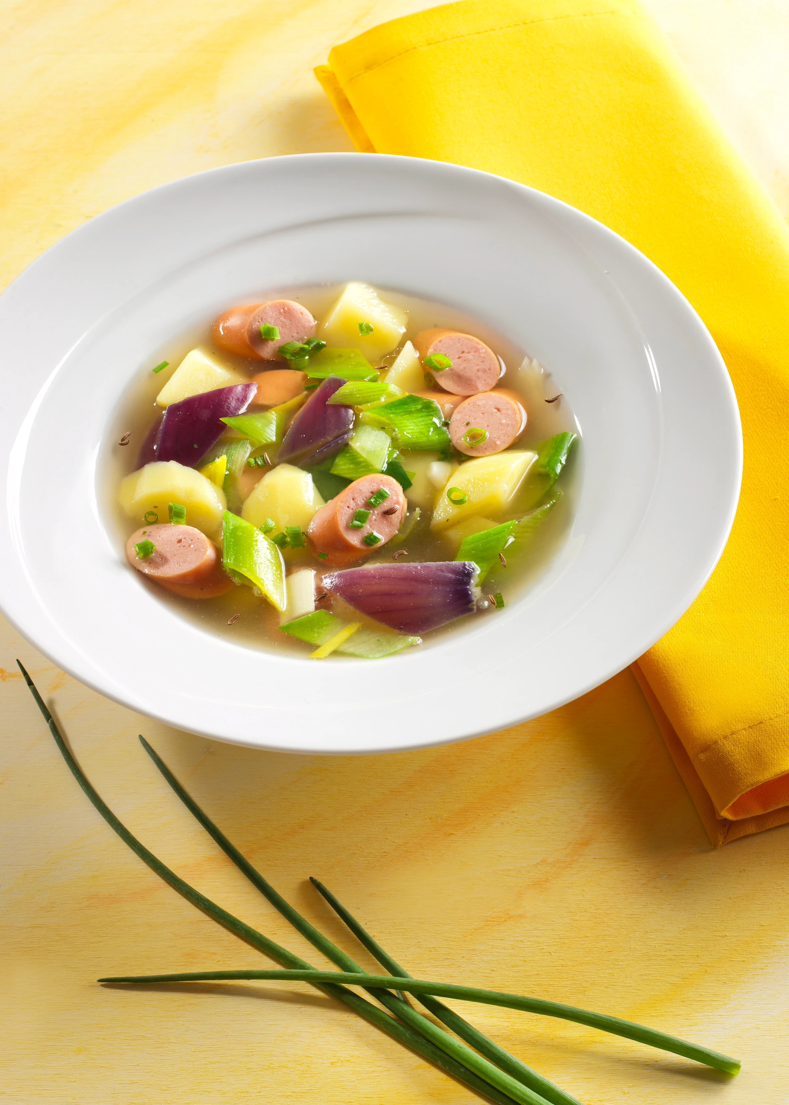 Klare Erdäpfel-Lauchsuppe mit Würsteln