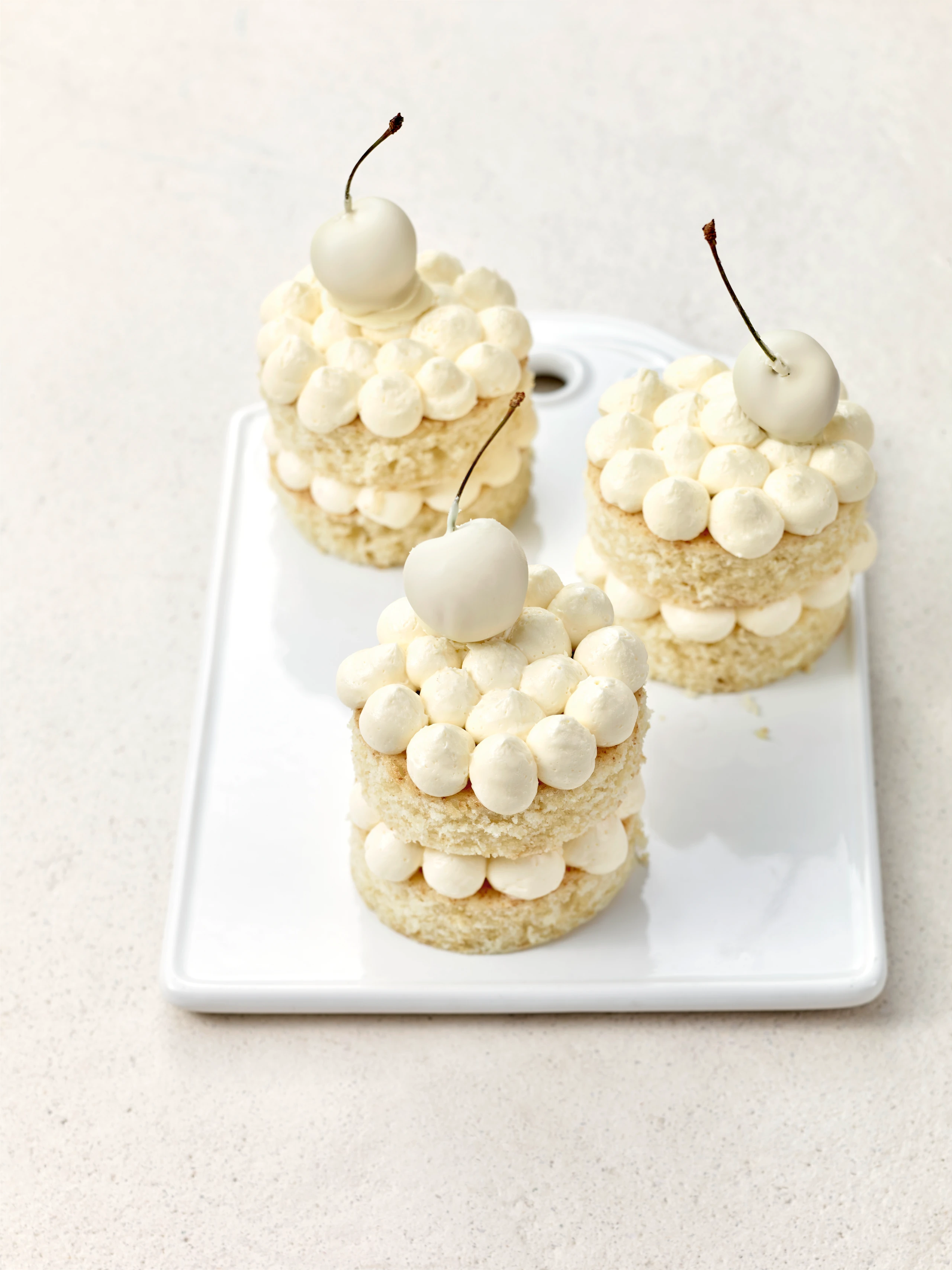 Weiße Törtchen mit getunkten Kirschen