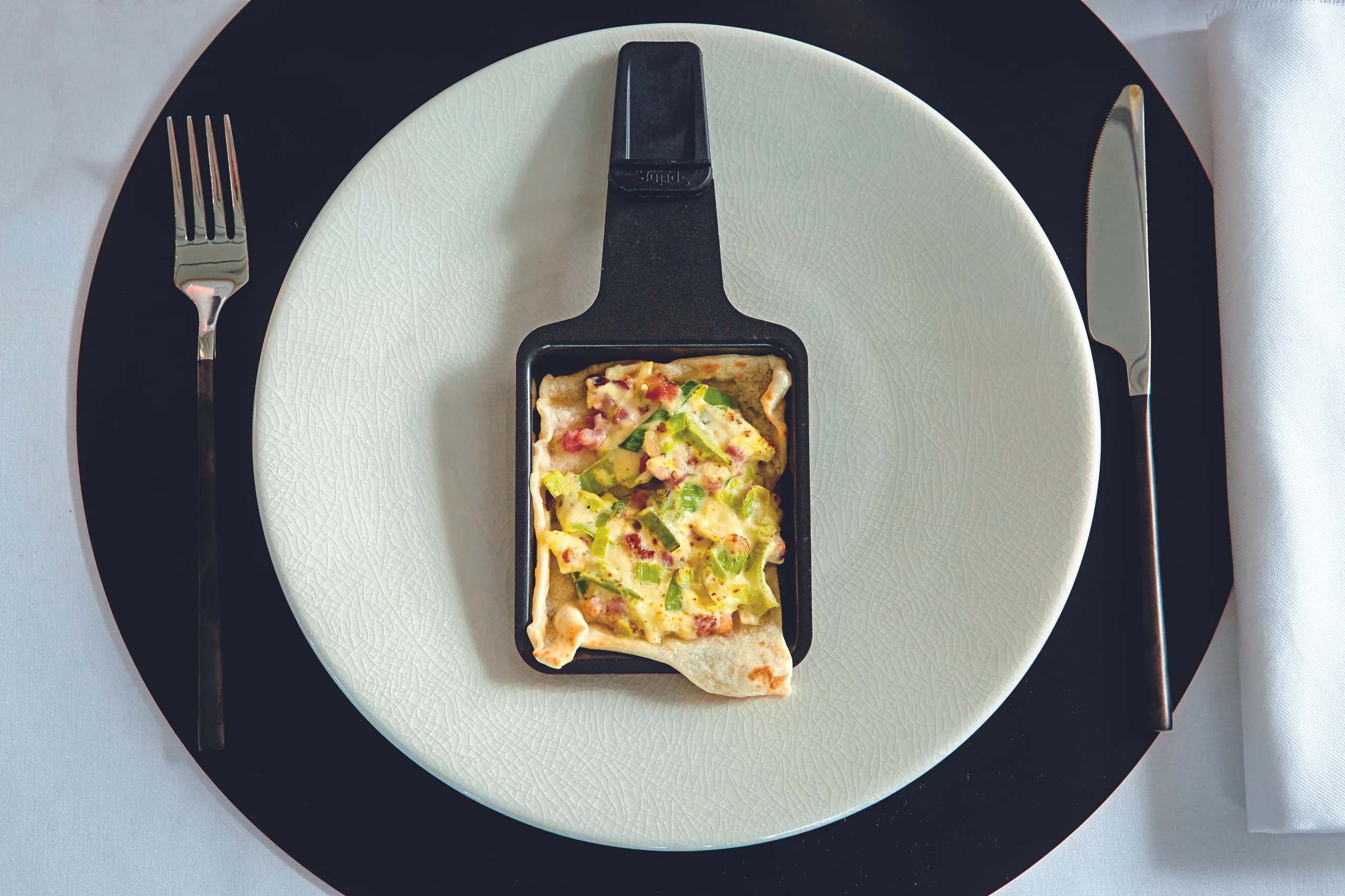 Raclette: Flammkuchen-Pfännchen mit Lauch und Speck