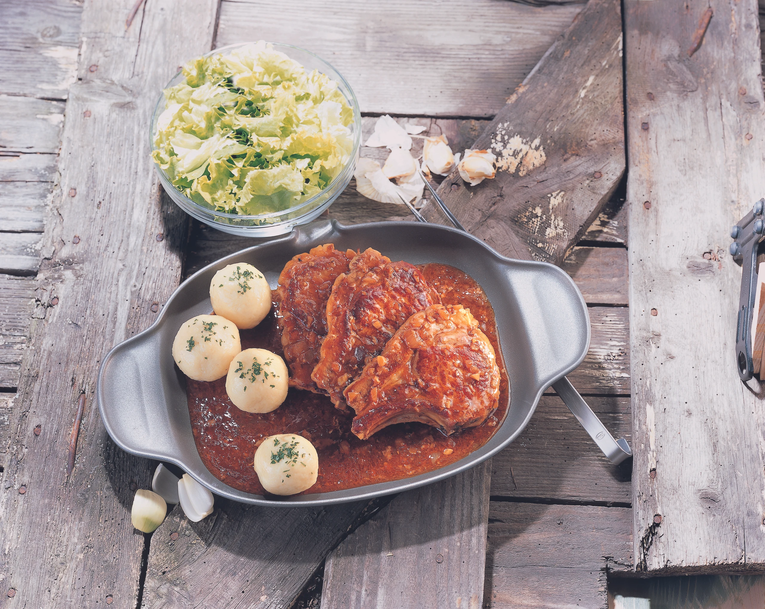 Schweinskoteletts mit Kümmelglace, Erdäpfelknödeln und Eisbergsalat