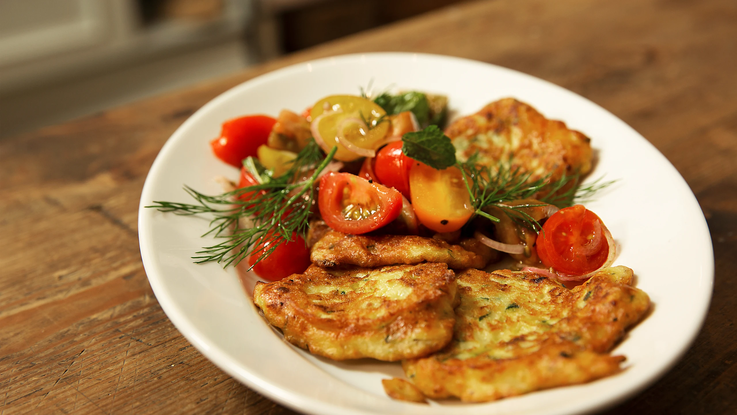 © G+J Digital Products Zucchini-Ricottapuffer mit buntem Paradeisersalat