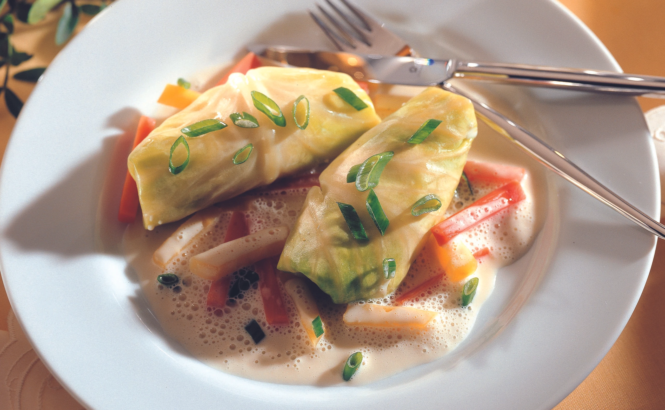 Krautröllchen auf Wurzelgemüse mit Zwiebel-Oberssauce