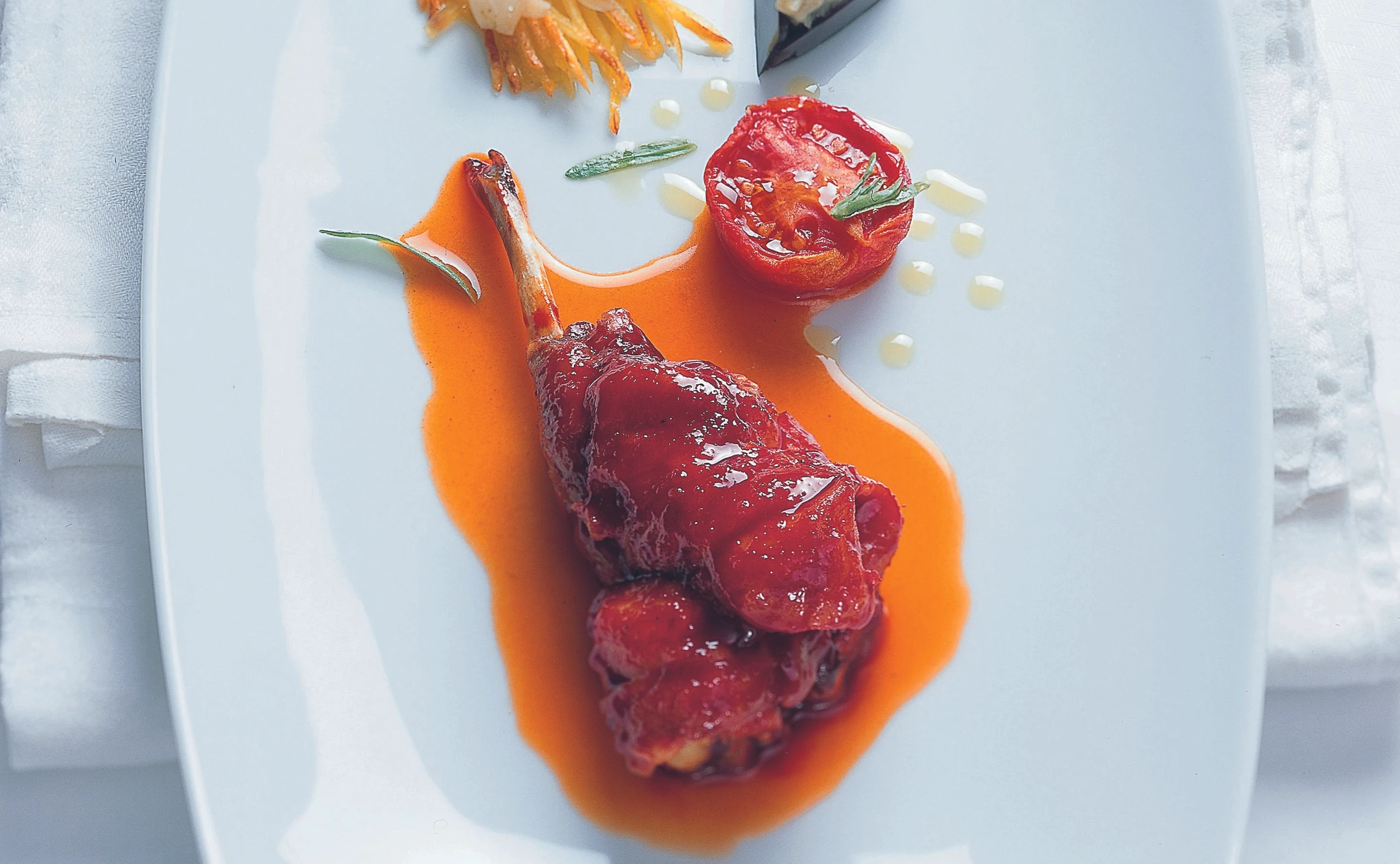 Kaninchenkeule im Tomaten-Paprikasaft mit Mandelrösti