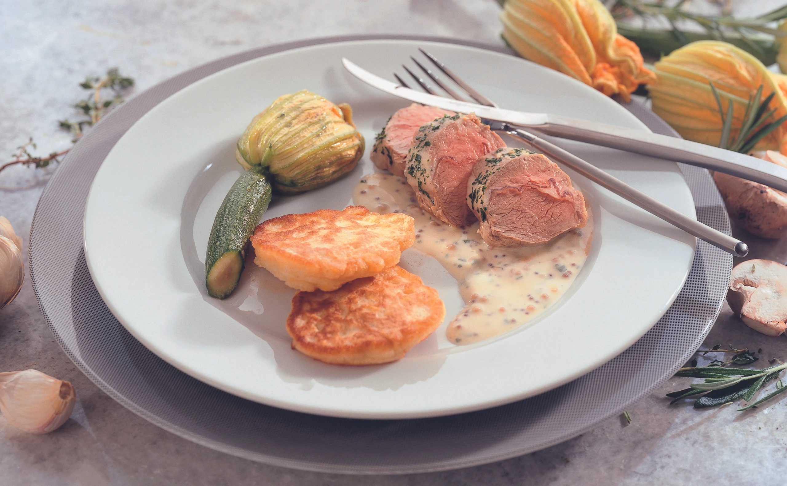 Pochiertes Lammrückenfilet mit Maisblinis und gefüllten Zucchiniblüten